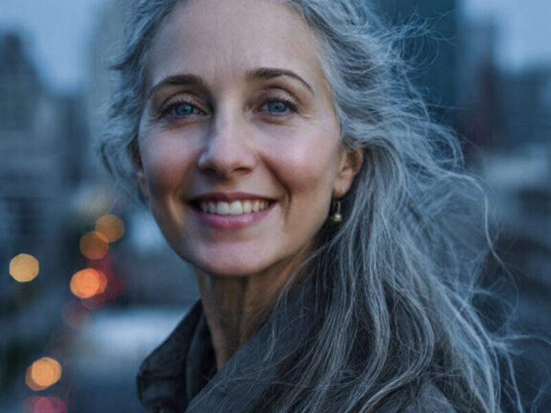 Woman standing on a quiet city street at night under soft streetlights